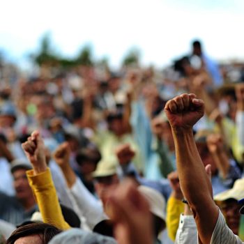 A picture of raised fists at a protest. (Credit: commons.wikipedia.org)